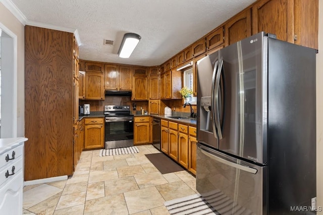 kitchen featuring stainless steel appliances, decorative backsplash, a textured ceiling, ornamental molding, and sink