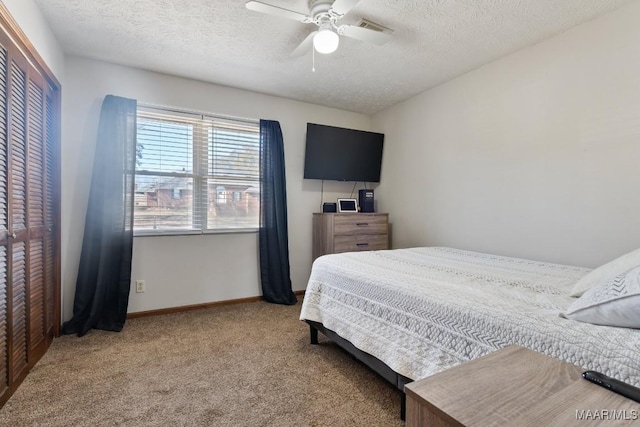 bedroom featuring a textured ceiling, ceiling fan, carpet flooring, and a closet