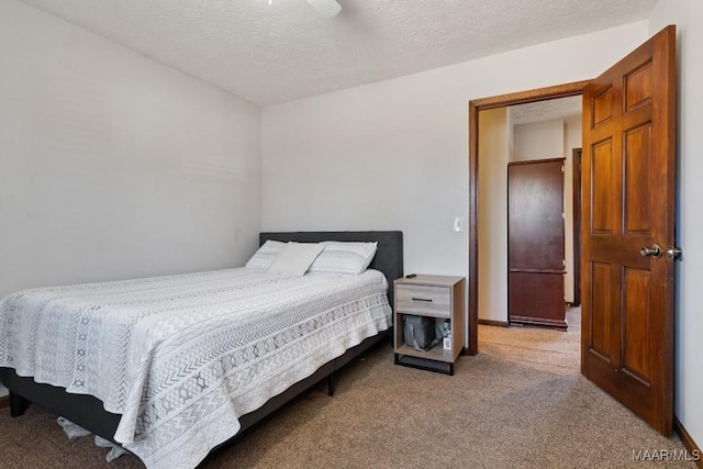 bedroom featuring ceiling fan, a textured ceiling, and carpet flooring