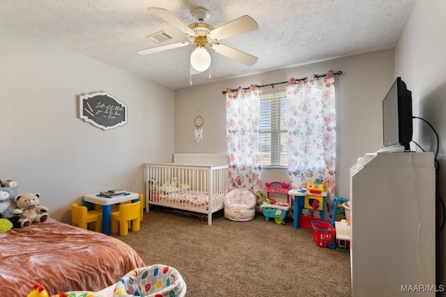 carpeted bedroom featuring ceiling fan and a textured ceiling