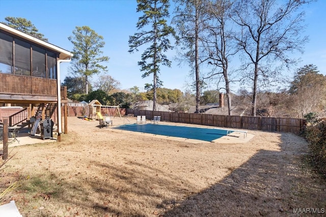 view of pool featuring a playground, a patio area, and a sunroom