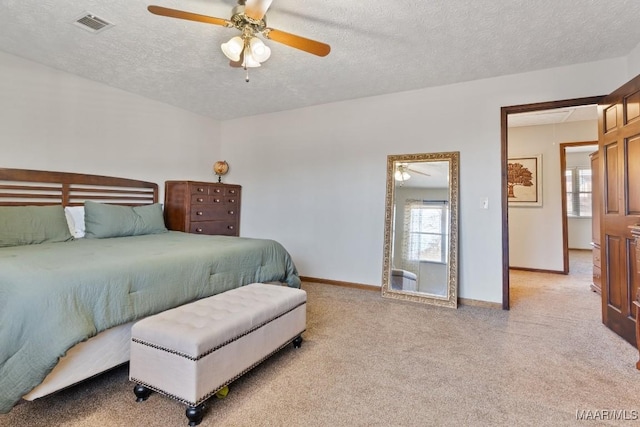 carpeted bedroom with ceiling fan and a textured ceiling