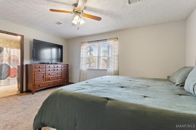 carpeted bedroom with ceiling fan and a textured ceiling