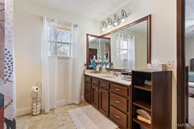 bathroom with vanity, plenty of natural light, and a textured ceiling