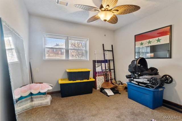 misc room featuring a textured ceiling, ceiling fan, and carpet