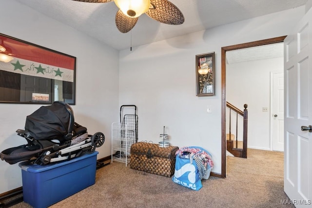 miscellaneous room featuring a textured ceiling, ceiling fan, and carpet