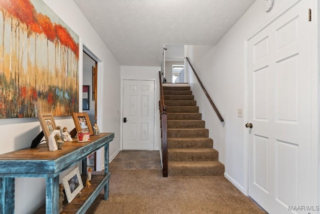 staircase featuring a textured ceiling and carpet floors