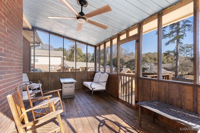 sunroom / solarium featuring ceiling fan, plenty of natural light, and wooden ceiling