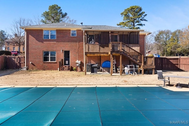 rear view of property featuring a covered pool