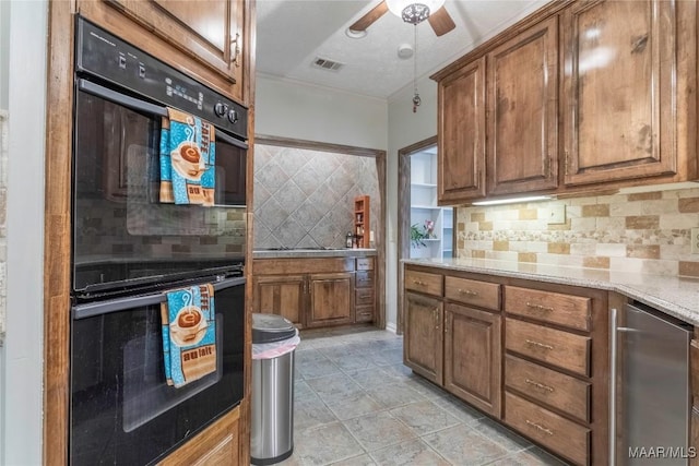 kitchen with backsplash, black double oven, light stone counters, and refrigerator