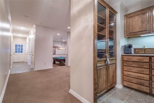 kitchen featuring light colored carpet, crown molding, and pool table