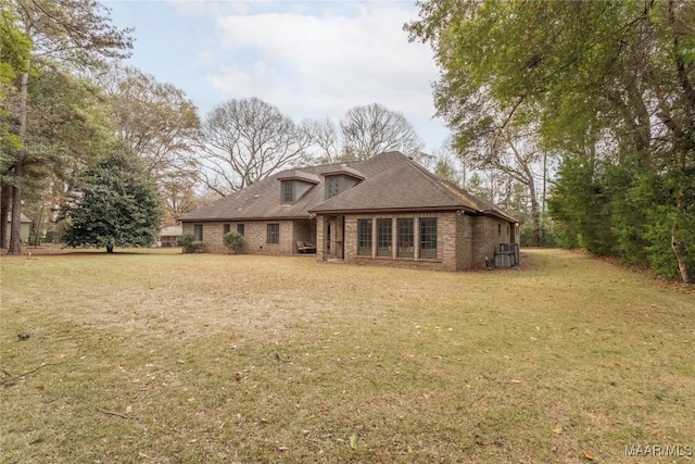 back of property with a lawn and central AC