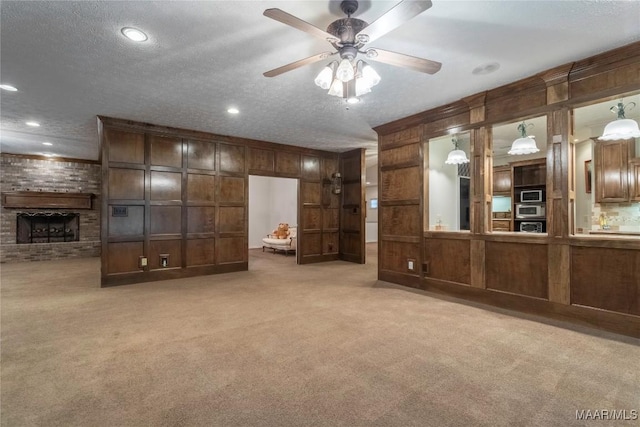 unfurnished living room with a textured ceiling, light colored carpet, and ceiling fan