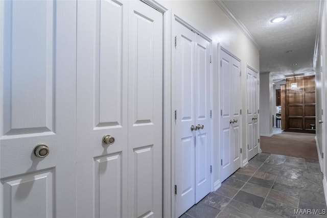 hallway featuring a textured ceiling and ornamental molding