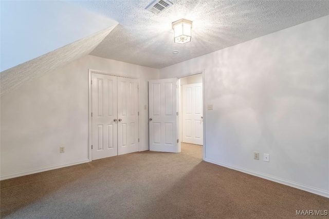 bonus room featuring a textured ceiling, light colored carpet, and vaulted ceiling