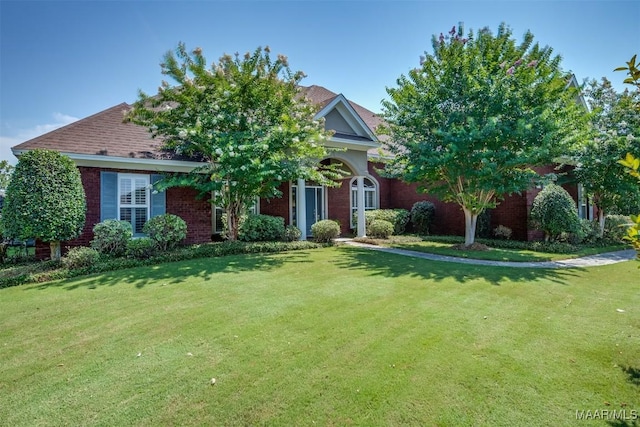 view of property hidden behind natural elements with a front lawn