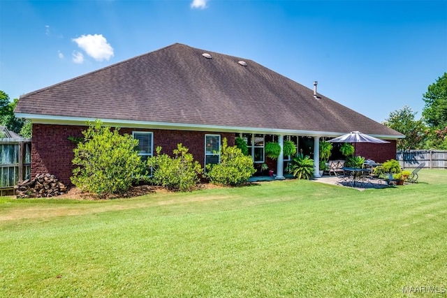 rear view of property with a patio area and a lawn