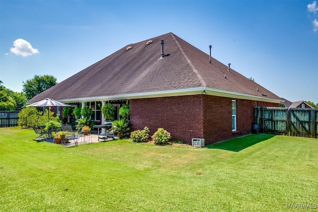 back of house with a yard and a patio