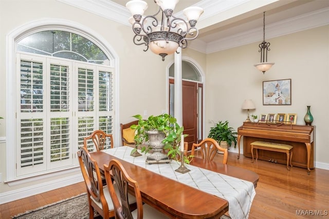 dining room featuring light hardwood / wood-style flooring, crown molding, and an inviting chandelier