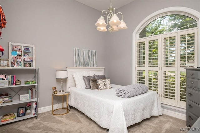 carpeted bedroom featuring a notable chandelier