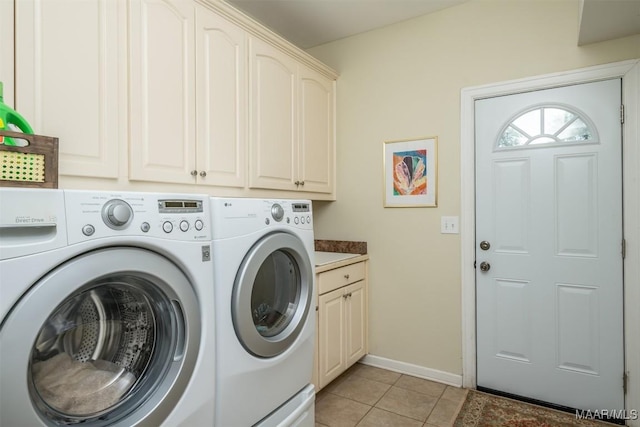 washroom featuring cabinets, light tile patterned floors, and washing machine and clothes dryer