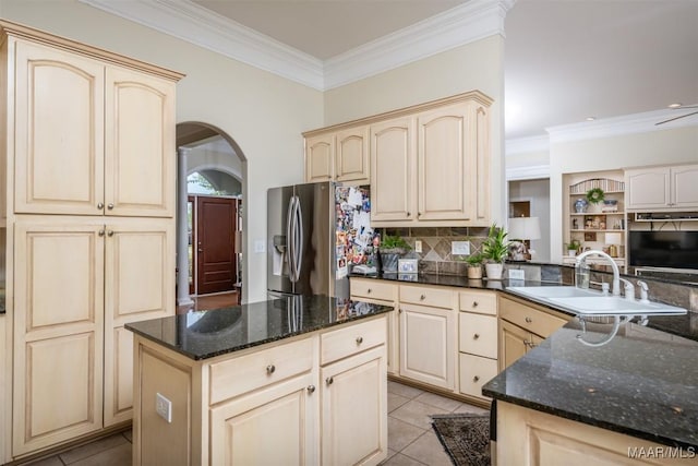 kitchen featuring sink, kitchen peninsula, dark stone countertops, light tile patterned floors, and stainless steel fridge with ice dispenser