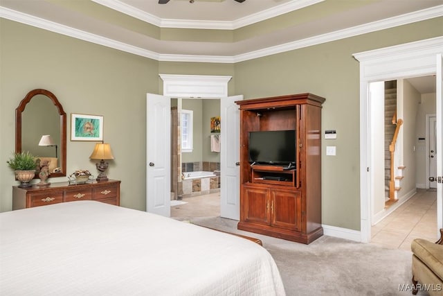 carpeted bedroom featuring a tray ceiling, ensuite bath, crown molding, and ceiling fan