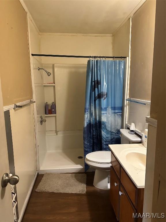 bathroom with hardwood / wood-style floors, vanity, toilet, and walk in shower