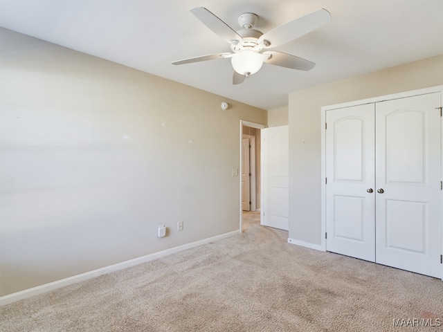 unfurnished bedroom with ceiling fan, a closet, and light carpet