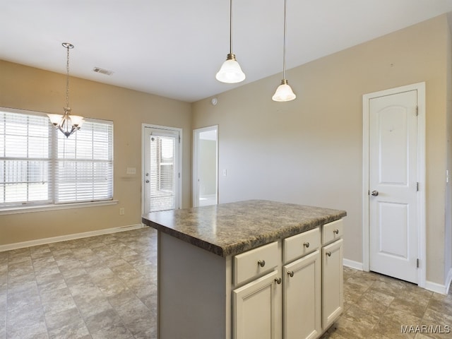 kitchen with decorative light fixtures, a kitchen island, and a chandelier