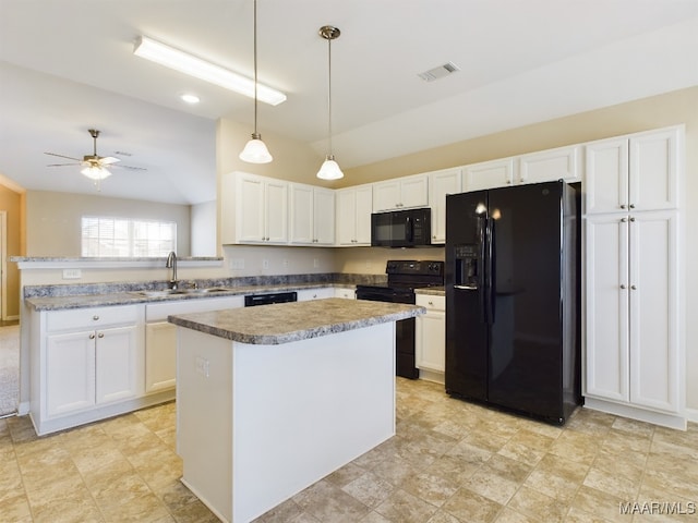 kitchen featuring white cabinetry, a center island, black appliances, and vaulted ceiling