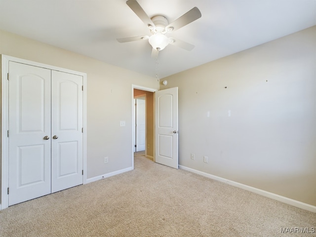 unfurnished bedroom with ceiling fan, light colored carpet, and a closet