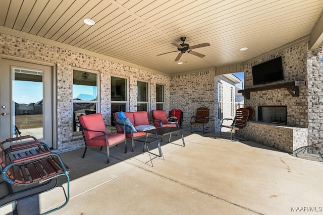 view of patio / terrace featuring an outdoor living space with a fireplace and ceiling fan