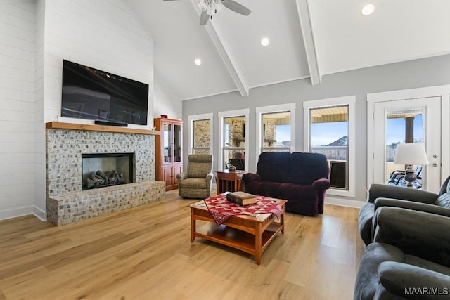 living room with beamed ceiling, ceiling fan, light wood-type flooring, and high vaulted ceiling