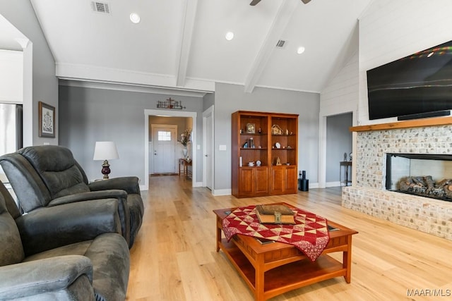 living room with vaulted ceiling with beams, light hardwood / wood-style floors, and ceiling fan