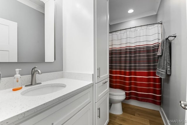 bathroom with vanity, hardwood / wood-style flooring, toilet, and crown molding