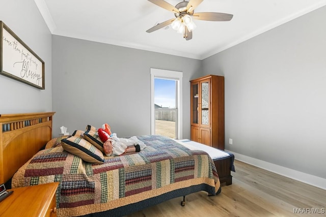 bedroom featuring ceiling fan, ornamental molding, and light wood-type flooring