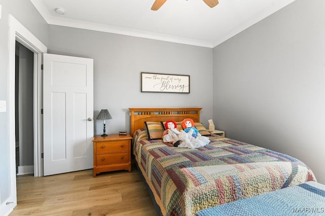 bedroom with ceiling fan, crown molding, and light wood-type flooring