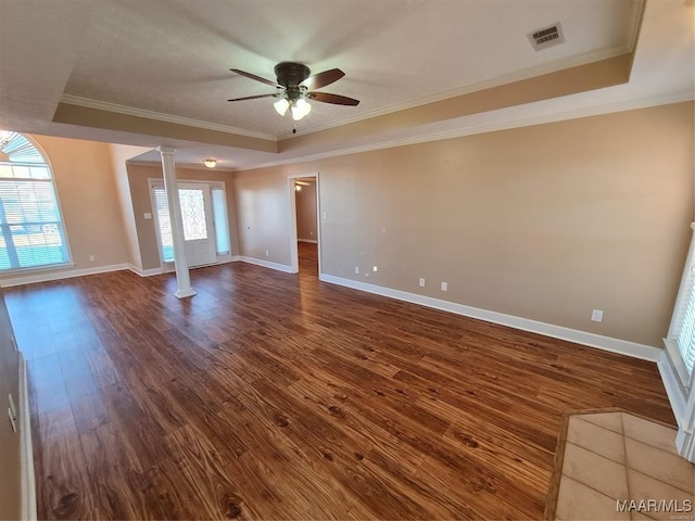 unfurnished room featuring hardwood / wood-style flooring, decorative columns, crown molding, and a tray ceiling