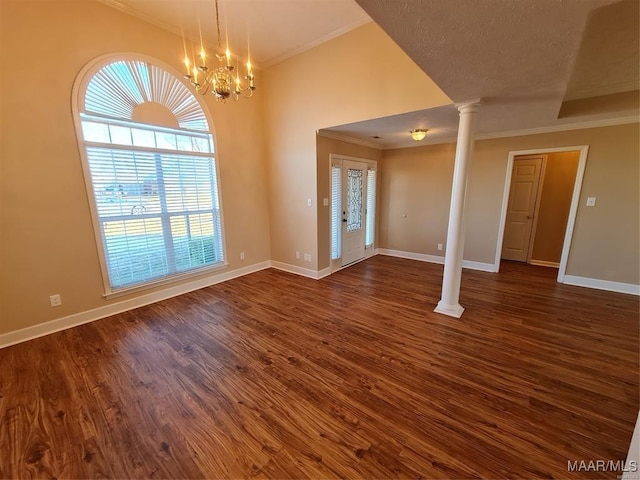 interior space featuring a chandelier, dark hardwood / wood-style flooring, ornate columns, and crown molding