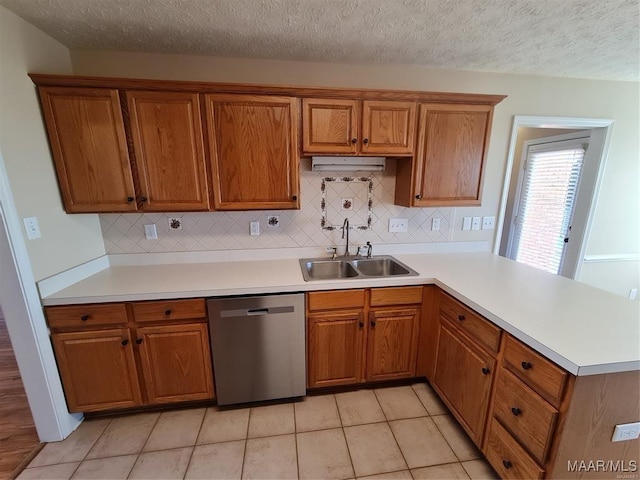 kitchen featuring sink, light tile patterned flooring, stainless steel dishwasher, and a textured ceiling