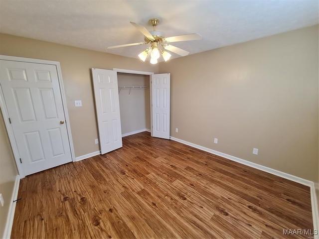 unfurnished bedroom featuring ceiling fan, a closet, and wood-type flooring