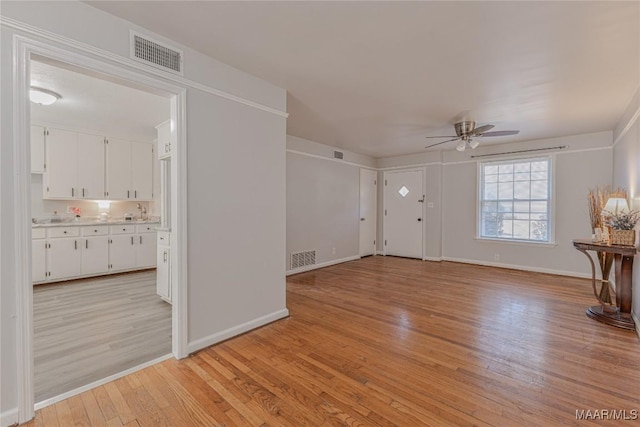 unfurnished living room featuring ceiling fan and light wood-type flooring