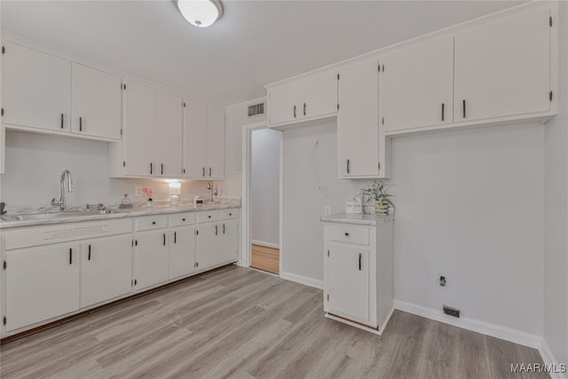 kitchen featuring white cabinets, sink, and light hardwood / wood-style flooring