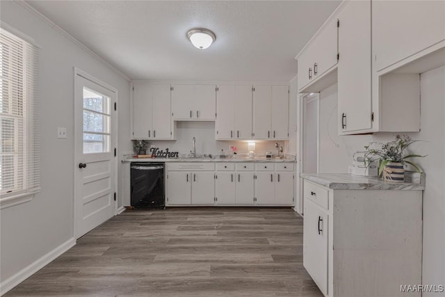 kitchen featuring dishwasher, white cabinets, and light hardwood / wood-style flooring