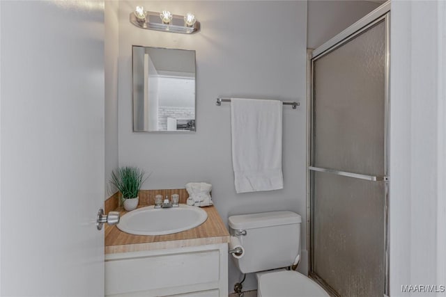 bathroom featuring vanity, toilet, and an enclosed shower