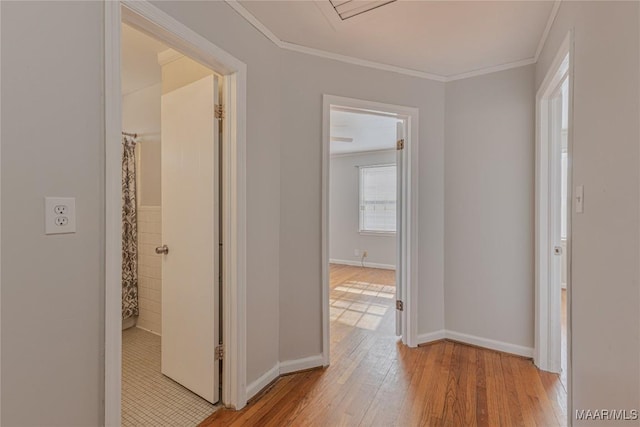 corridor with crown molding and light hardwood / wood-style flooring