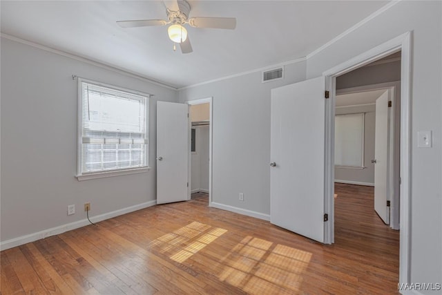 unfurnished bedroom featuring ceiling fan, light hardwood / wood-style floors, ornamental molding, and a closet