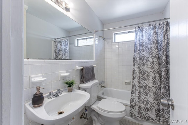 full bathroom featuring sink, toilet, shower / bathtub combination with curtain, and tile walls