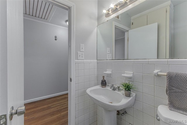 bathroom with sink, toilet, tile walls, and hardwood / wood-style flooring